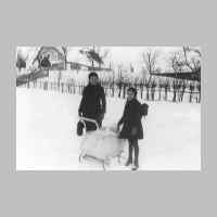 022-0519 Gerda Hermann links und Schwester Irmgard mit Hans-Juergen Erzberger im Kinderwagen im Winter 1942-43. Hintergrund Haus Ernst Neumann.JPG